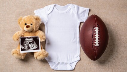 A Heartwarming Announcement of a New Arrival: Baby Onesie, Ultrasound Photo, Teddy Bear, and Football Celebrate Family and Future Moments Together