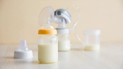 Manual breast pump and sterilized bottles filled with expressed milk for World Breastfeeding Week campaign