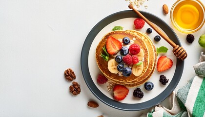 top view healthy oatmeal pancakes with fresh fruits and honey on white background