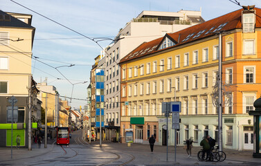 Modern tram travels along a quiet Hurbanovo street in Bratislava during a day with historical architecture in view