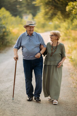 Happy elderly people walking in the park on a sunny day