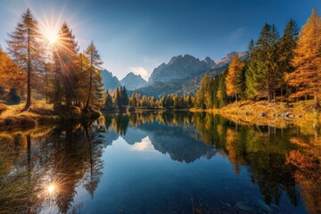 Naklejka premium Serene mountain lake surrounded by vibrant autumn forest and towe peaks under clear blue sky du bright sunny day