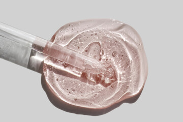 Liquid pipette serum pink gel on light grey colored isolated background