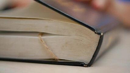 Feminine hand trace Bible scripture and religion. Holy book rests open. Finger moves over sacred text. Deep study of divine words. Christian faith and spiritual understanding