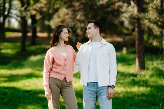 Couple enjoying a sunny afternoon stroll through a lush green park