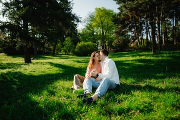 Couple shares a tender moment in a sunlit park during springtime