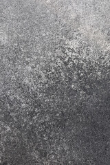 Surface texture of dark stone with subtle patterns in natural light setting