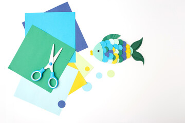 Playful fish paper art project using cut circles and scissors for homeschool resources, craft subscription boxes, educational publishers, toy design, and fine motor skill activity books.