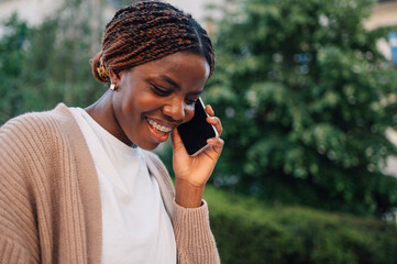 Young woman smiling and talking on mobile phone outdoors