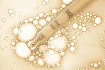 Liquid yellow gel or serum with pipette dropper on white isolated background