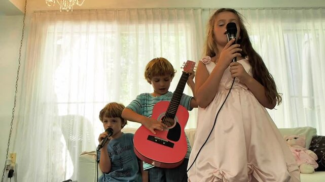 Young children staring a band in the living room 