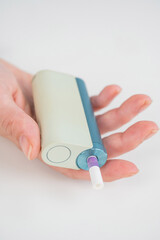 Woman holding electronic cigarette on white background. Tobacco heating systems.