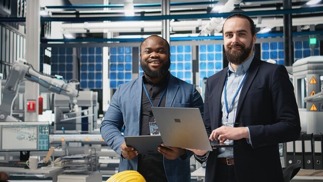 Team of diverse analysts consultants reviewing data and checklists in a high tech solar panel plant, ensuring manufacturing process meets sustainable energy and innovation standards. Camera A. - Powered by Adobe