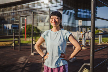 Japanese woman in a sportswear stand in park ready for workout