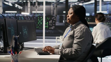 Annoyed data center employee making rude hand gesture toward colleague during workplace...