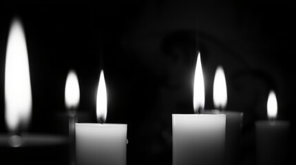 Candles of Remembrance: Four candles burning brightly in the darkness, each flame a beacon of hope and remembrance.  A monochromatic image evokes a sense of peace and quiet contemplation.