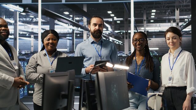 Happy data center engineering team members collaborating on neural network software development. Smiling server hub coworkers implementing machine learning technology in workplace, camera A - Powered by Adobe
