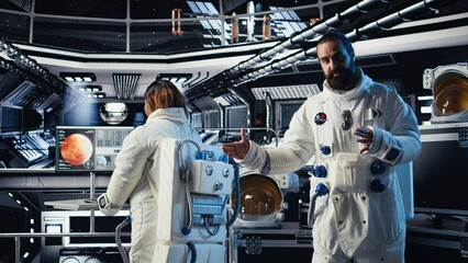 Astronaut waves hand, communicating with command center during videocall to share recent orbit...