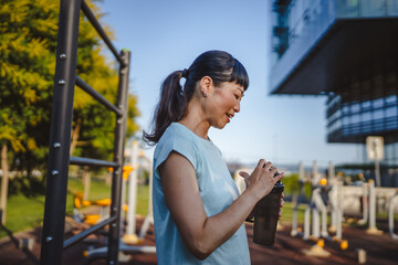 Mature japanese woman take a brake resting with supplement shaker
