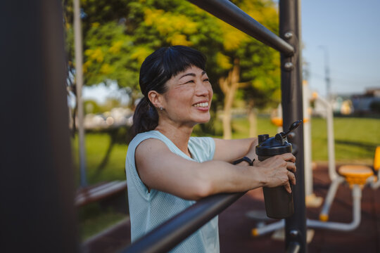 Mature japanese woman take a brake resting with supplement shaker