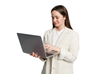 Woman in light blazer working on laptop with a focused expression while standing against a clean white background