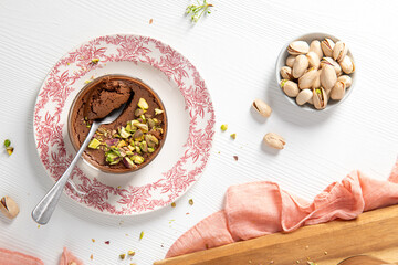 A top-down view of chocolate pudding with pistachios