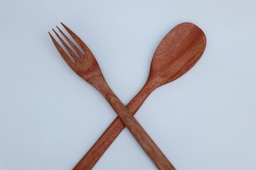 Wooden spoon and fork on white background
