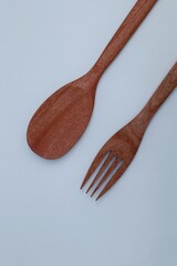 Wooden spoon and fork on white background