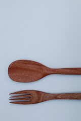 Wooden spoon and fork on white background