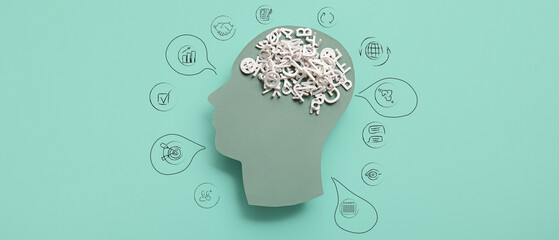 Paper human head with many letters on color background. Concept of brainwork