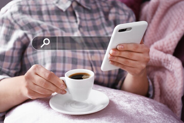 Young woman with mobile phone drinking coffee at home