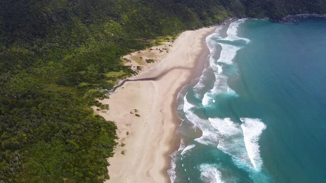 Drone shot of pristine Rada Ranu beach with crashing waves and dense green forest in southern Chile &ndash; Pacific coastline and natural wilderness