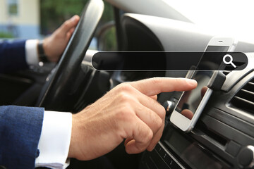 Businessman using mobile phone for navigation while driving car, closeup