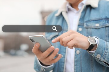 Young man with mobile phone using web search engine, closeup