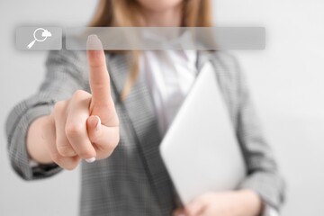 Businesswoman using web search engine on light background, closeup
