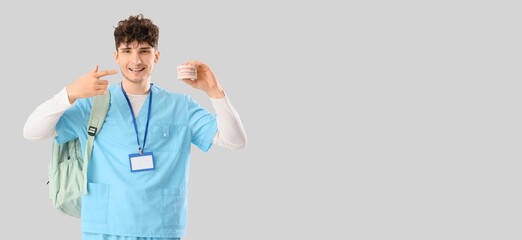 Male medical student with jaw model on grey background with space for text