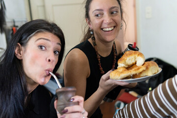 Two women enjoying mate and pastries in a joyful moment