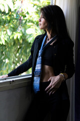Woman with denim tie and long hair lost in thought