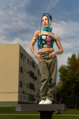 Fashionable woman with unique hair in an urban green space
