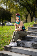 Woman with distinctive hair and fashion in an urban park