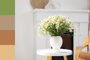 Vase with chamomiles on table in living room. Different color patterns