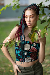 Young woman with braids and creative fashion in a natural setting