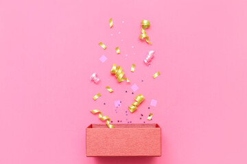 Composition with wooden box and confetti on pink background