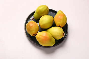 Plate with fresh pears on white background