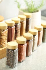 Many different aromatic spices in jars on table indoors, closeup