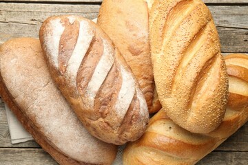 Many bread loaves on wooden table, top view