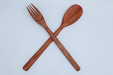 Wooden spoon and fork on white background
