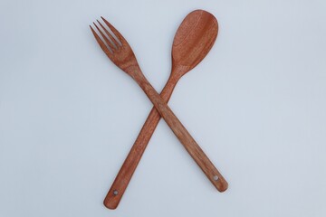 Wooden spoon and fork on white background