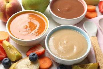 Baby food. Tasty puree in bowls and different ingredients on table, above view