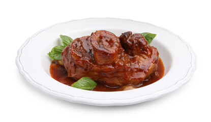 Traditional ossobuco dish with beef steak, sauce and basil isolated on white